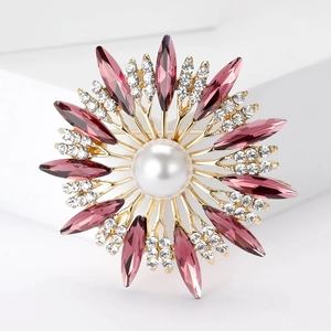 Detailed close-up of sunflower brooch with large white pearl and purple crystals