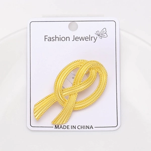 Close-up of vintage gold bow brooch featuring a sophisticated textured metal finish