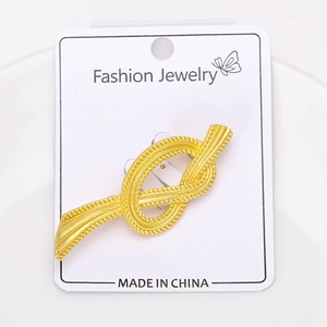 Macro detail of French vintage matte gold rope knot brooch with intricate braided texture