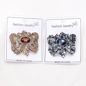Close-up of vintage crystal glass brooches in blue and pink bow shapes on display cards