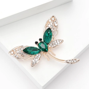 Luxurious rhinestone dragonfly brooch with deep green gems and white crystal wings