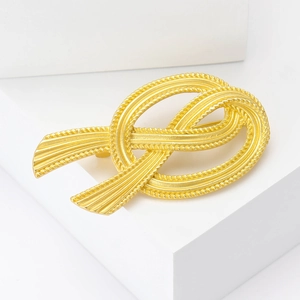 Vintage French style gold ribbon bow brooch with textured metallic finish for elegant suits