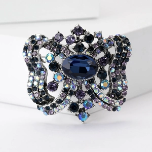 Vintage luxury brooch featuring deep blue crystal centerpiece and intricate rhinestone details
