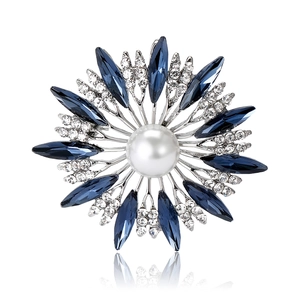 Elegant silver sunflower brooch with blue rhinestones and a large center white pearl