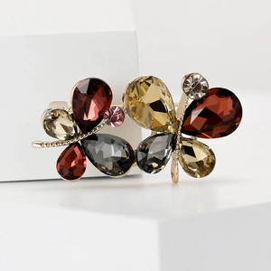 Détail d'une broche papillon plaquée or avec des strass multicolores et des cristaux
