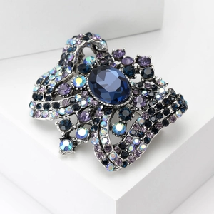Vintage style crystal brooch featuring a large deep blue oval stone and colorful rhinestones