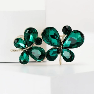 Broche papillon dorée exquise avec pierres précieuses vert émeraude sur podium