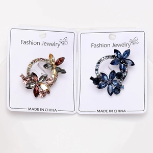 Detailed view of rhinestone wreath brooches in warm amber and cool blue crystal clusters
