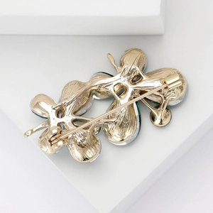 Détail macro d'une broche papillon montrant le placage d'or et le fermoir de sécurité