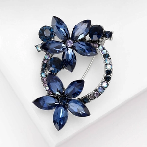 Elegant floral wreath brooch with deep blue and lavender crystals in marquise cut design