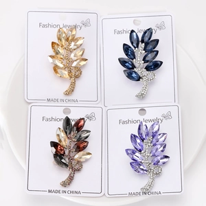 Détail de quatre broches feuilles en cristal en or, bleu et violet sur cartes