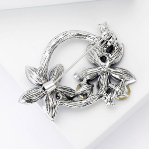 Detail view of silver flower wreath brooch back showing safety pin clasp and craftsmanship