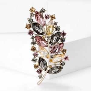 Elegant vintage leaf brooch with colorful crystals on a golden alloy base for suits