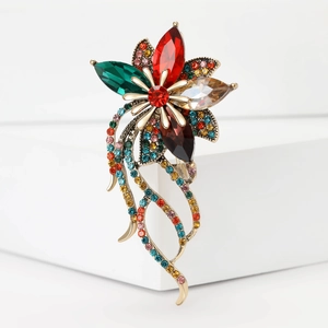 Dettaglio di una spilla floreale vintage con strass colorati su supporto geometrico