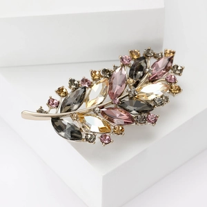 Detailed macro view of an elegant leaf brooch featuring multi-color sparkling crystals