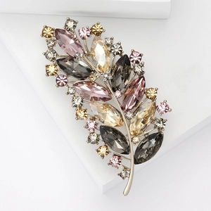 Elegant gold feather brooch with luxury crystals in smoky grey and champagne tones