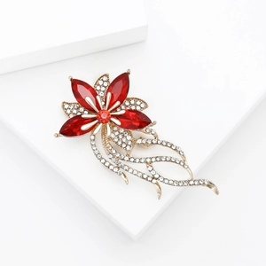 Elegante spilla a fiore vintage con strass rossi e nappe su supporto bianco moderno