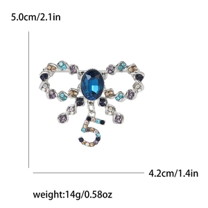 Detail of bow brooch with blue rhinestones and crystal number five pendant