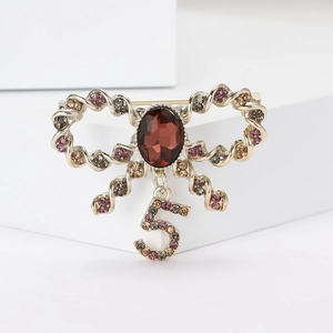 Elegant gold bow brooch with red gemstone, rhinestones and number 5 pendant