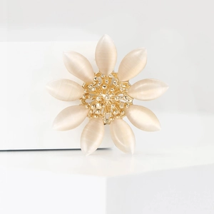 Broche marguerite en émail blanc élégante avec centre doré sur présentoir chic