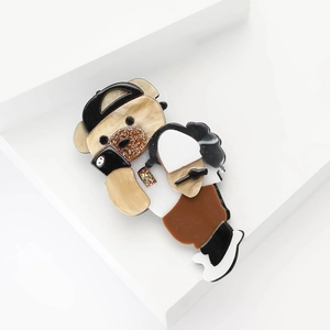 Broche ours mignon en acrylique avec casquette et t-shirt sur support minimaliste