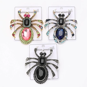 Vue détaillée de broches d'araignée vintage en alliage avec strass colorés sur des cartes