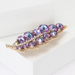 Dettaglio della spilla a foglia con cristalli blu-viola e finitura color oro