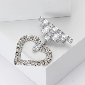 Elegante spilla a cuore in argento con cristalli brillanti su un podio bianco