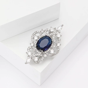 Broche royale élégante en zircon ajouré avec pierre bleu foncé sur fond blanc