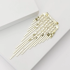 Detail view of heart-shaped brooch with golden tiered tassels and sparkling rhinestones