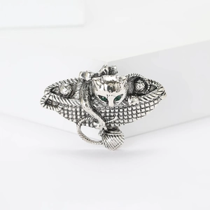 Macro detail of vintage cat brooch with green eyes and woven basket texture