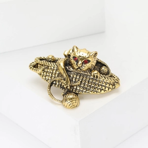 Vintage golden cat brooch in woven basket with red gemstone eyes for suits and coats