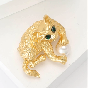 Chique gouden emaille kattenbroche met groene edelsteenogen en parelaccent