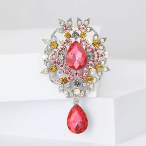 Macro detail of vintage silver brooch featuring large red teardrop crystals and rhinestones