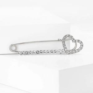 Broche cœur en alliage argenté avec strass brillants sur présentoir blanc épuré