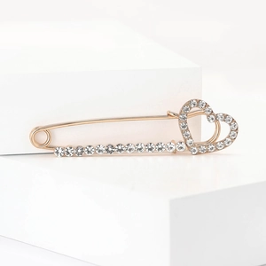 Broche cœur dorée élégante avec strass scintillants sur support en pierre minimaliste