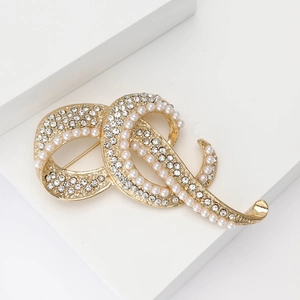 Eleganter goldener Knoten-Brosche mit Strass und Perlen auf weißem Sockel präsentiert