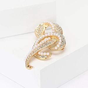 Eleganter Goldknoten-Brosche mit Kristallen und Perlen auf weißem Sockel