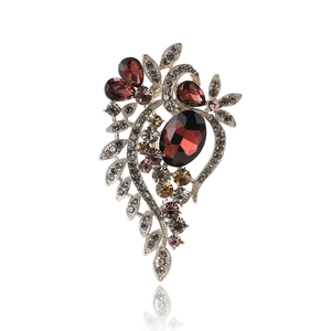 Vintage leaf brooch with deep red oval gemstones and crystal accents on silver alloy base