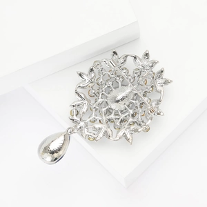 Detail view of vintage silver alloy leaf brooch with a pear-shaped waterdrop pendant