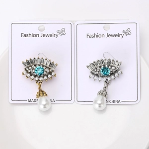 Détails macro des broches œil de démon dorées et argentées avec pierres et perles