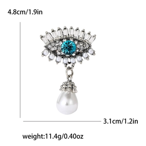 Détails de la broche œil de luxe avec pierre bleue et pendentif en perle