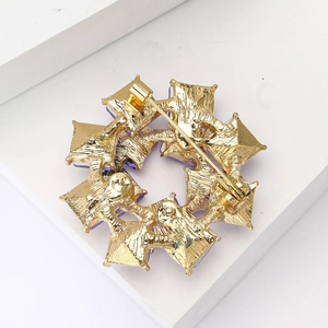 Macro shot of gold-plated alloy brooch back showing a secure pin clasp mechanism