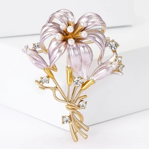 Detail einer eleganten Lilien-Brosche mit lila Emaille-Blüten und Perlenbesatz