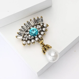 Broche œil avec strass bleu ciel, cristaux et pendentif en perle de goutte d'eau