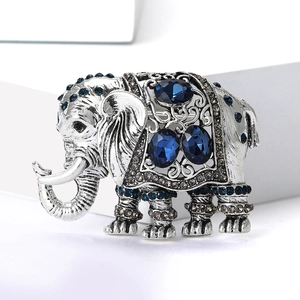 Detailopname van vintage zilveren olifant speld met blauwe strassteentjes en patronen