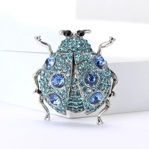 Vue détaillée d'une broche coccinelle avec cristaux bleu clair et pierres précieuses