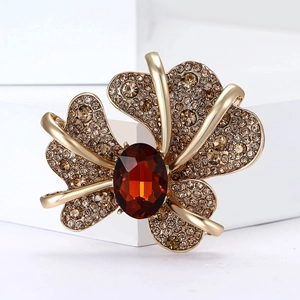 Macro detail of iris flower brooch with cognac oval stone and champagne crystals