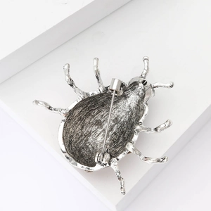 Vue détaillée du dos de la broche coccinelle en argent avec texture et épingle de sûreté