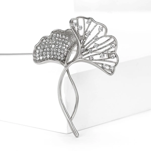 Detail of silver ginkgo leaf brooch featuring pavé crystals and elegant cutout design